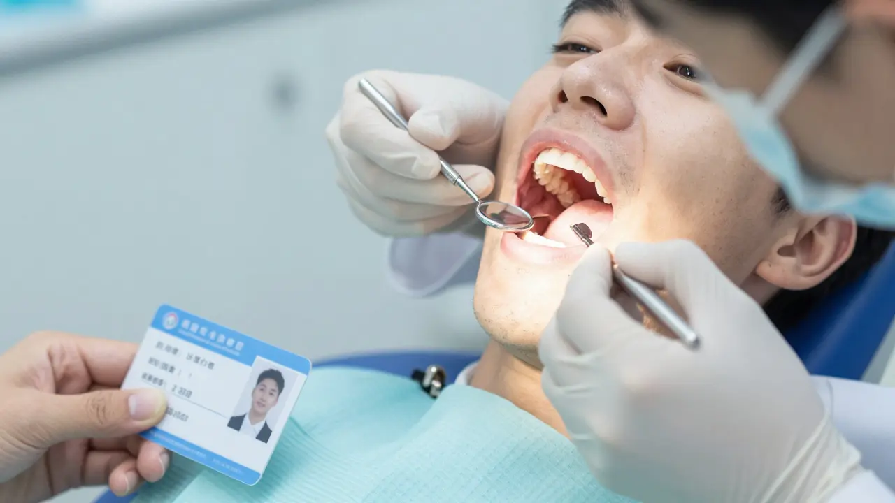 Dentist examining student's front teeth during a quick clinic check-up.